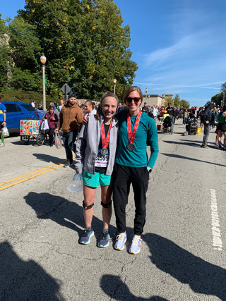 Jackie Whelan and Co-Founder Genny standing together with their medals at the end of the Chicago Marathon.