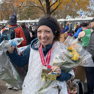 Mackenzie Lowe posing with flowers and a medal after a race.