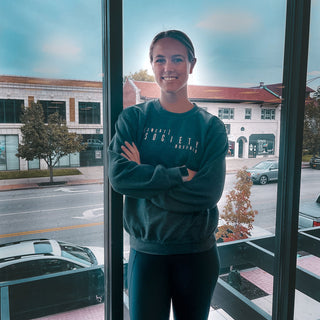 Molly Curry posing for Sweat Society as one of their coaches.