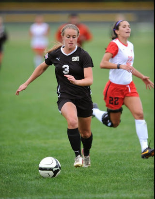 Molly Curry dribbling soccer ball.
