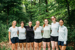 About Us. A group of 7 women all linking arms in Buffalo, NY wearing Middle Trail Running apparel. 