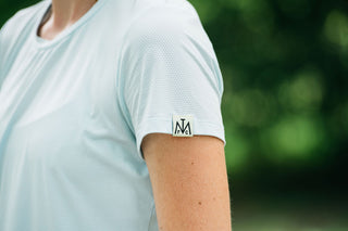 This women’s running shirt includes a lightweight, moisture-wicking fabric that is breathable. Running t-shirt comes in colors misty morning sky blue or sage green.