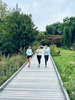 Women's Running Club - Boston. Three women running together on a boardwalk path in Boston, MA. 